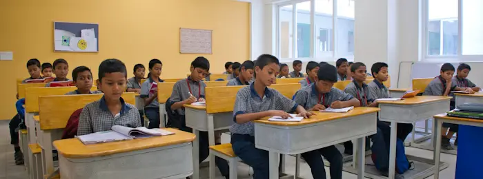 Children and educators in an Indian classroom setting that reflects consistent team-based support